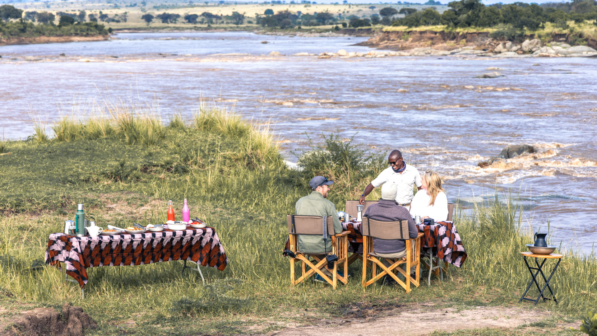 Serengeti National Park, lunch setup with guests and guide enjoying the view