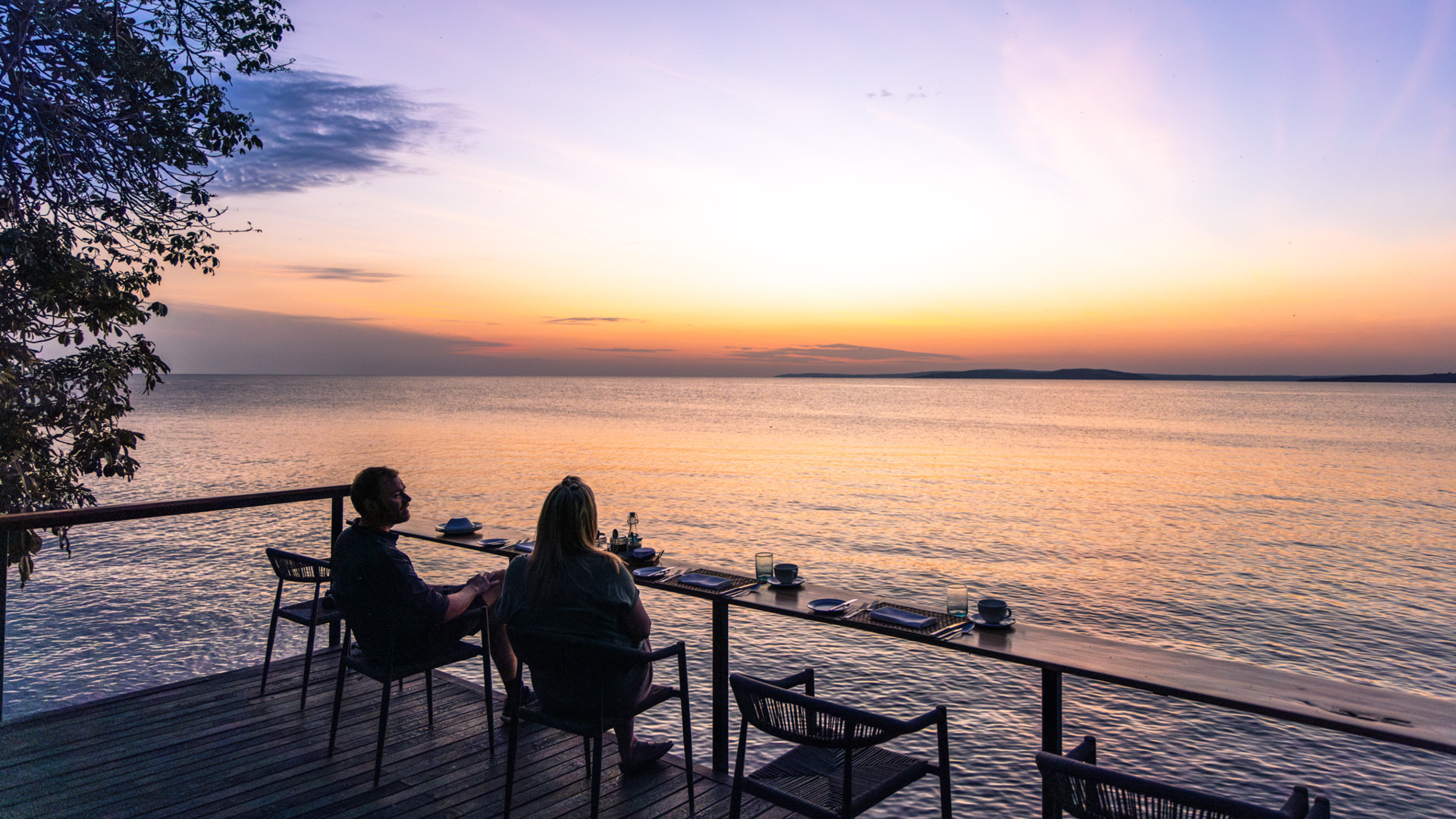 Sunset view over Lake Victoria, couple enjoying drinks