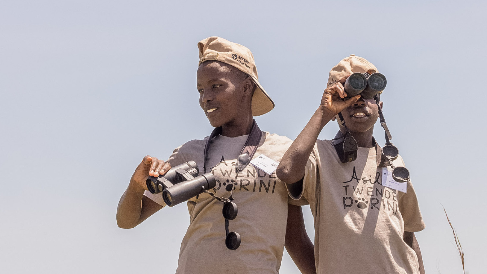 Two children with binoculars on an Asilia Africa Twende Porini trip at Rekero Camp in Tanzania