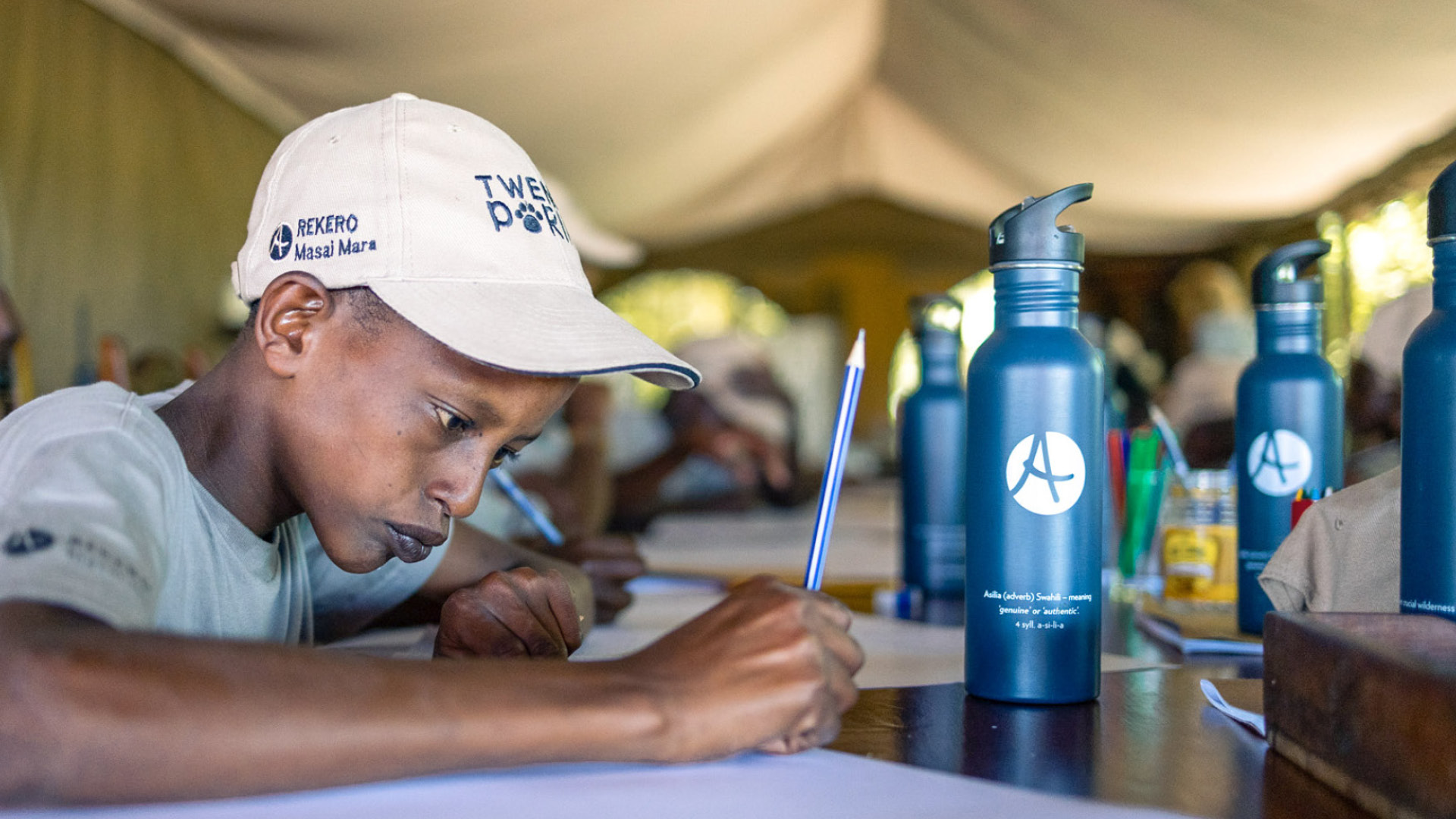 young boy learning on an Asilia Africa Twende Porini trip at Rekero Camp in Tanzania