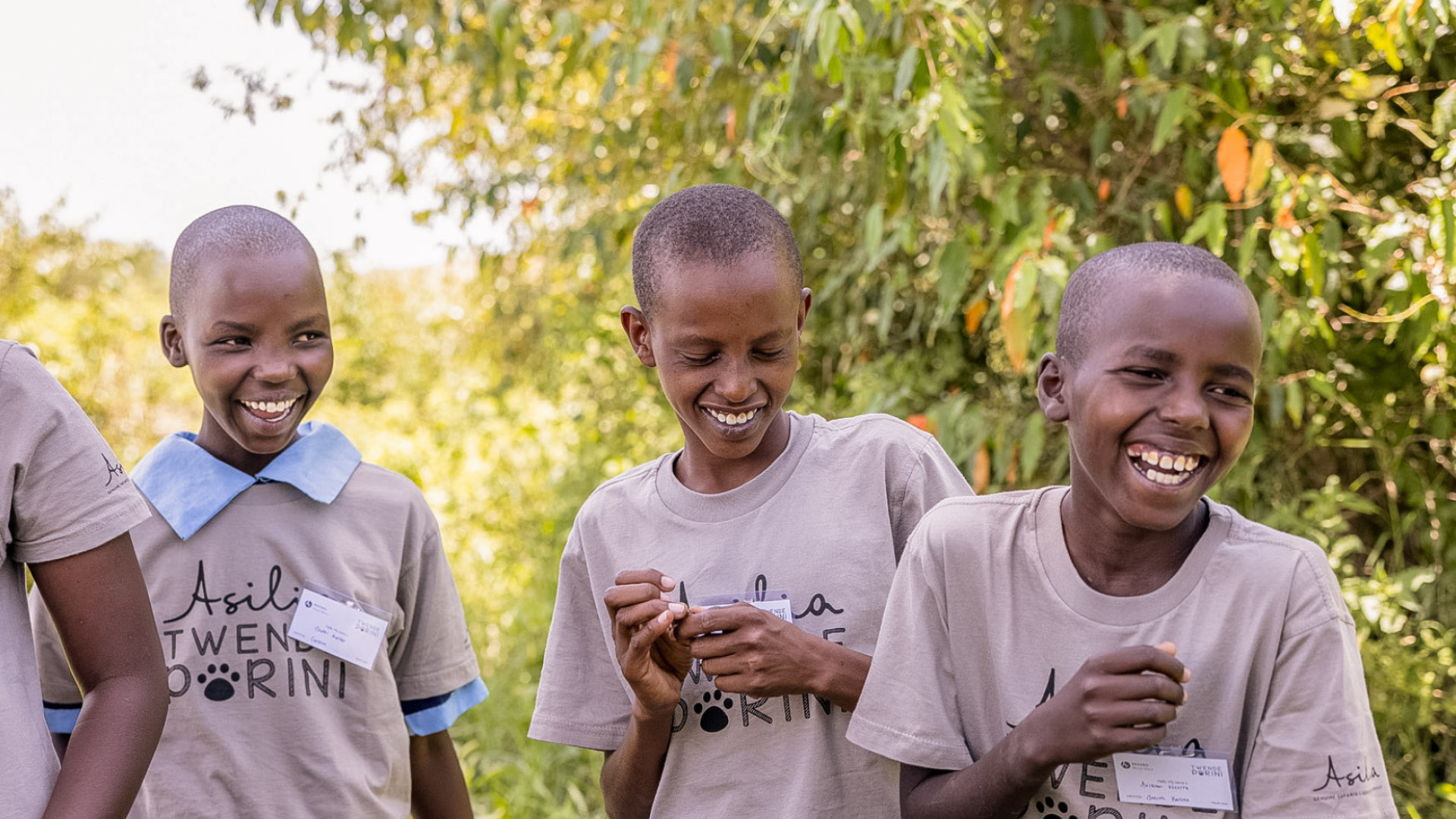 three laughing children on an Asilia Africa twende porini trip at Rekero Camp in Tanzania