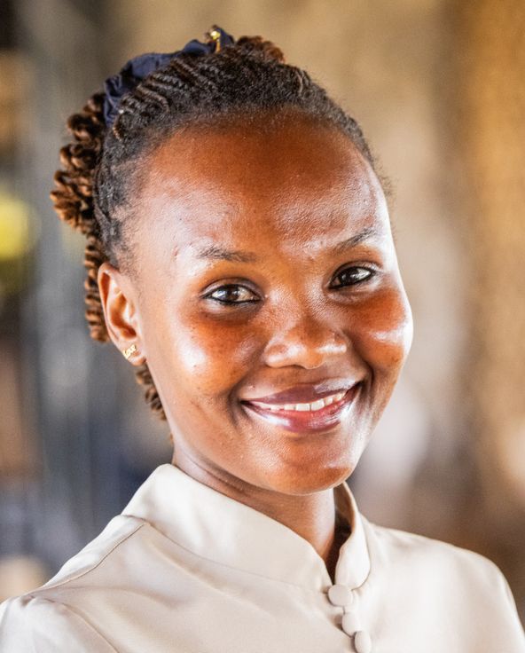 headshot of smiling waitress at namiri plains safari camp, tanzania, asilia africa