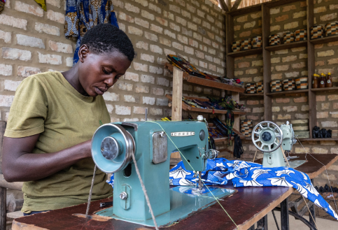 Nyamishana sits at her sewing machine table as part of Change A Life Bwindi
