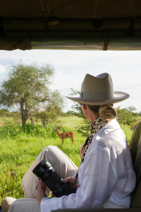 A woman in a white shirt on safari, Serengeti National Park, Tanzania.