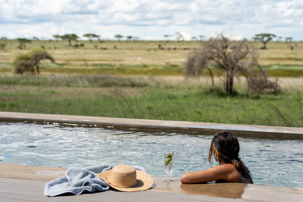 A guest enjoying the swimming pool at Namiri Plains, Serengeti National Park, Tanzania.