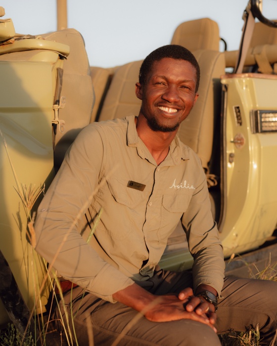 Daniel sitting on the side of his safari vehicle, Tanzania.