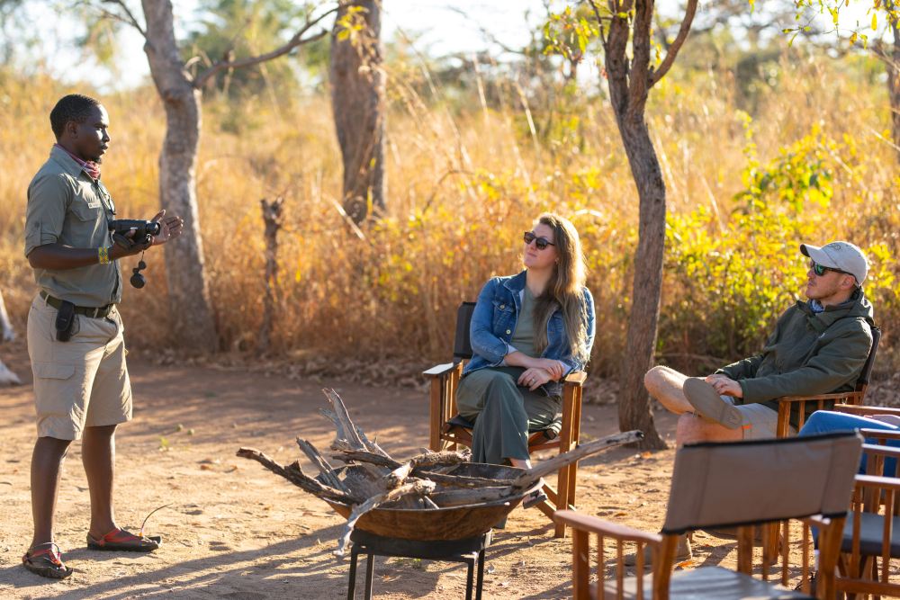 A local staff membre interacts with guests in Usangu Expedition Camp, Ruaha National Park, Tanzania.