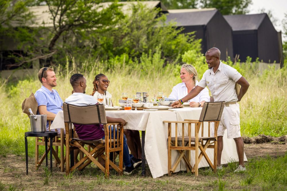 Guests enjoying an outdoor lunch at Olakira Camp, Serengeti National Park.